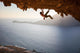 Rock climber climbing along roof in cave at sunset Wall Decal