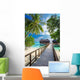 Bridge leading to overwater bungalow in blue lagoon Wall Decal