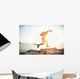 brave man running over rocks near ocean in beautiful sunset Wall Decal