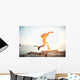 brave man running over rocks near ocean in beautiful sunset Wall Decal