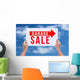 Two hands holding brown cardboard with garage sale on blue sky b Wall Decal