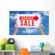Two hands holding brown cardboard with garage sale on blue sky b Wall Decal