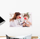 Smiling doctor examining success child with finger up Wall Decal
