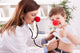 Smiling doctor examining success child with finger up Wall Decal