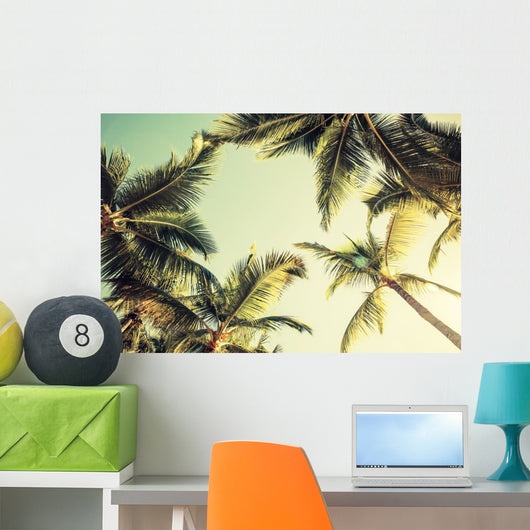 Coconut palm trees and shining sun over bright sky Wall Decal
