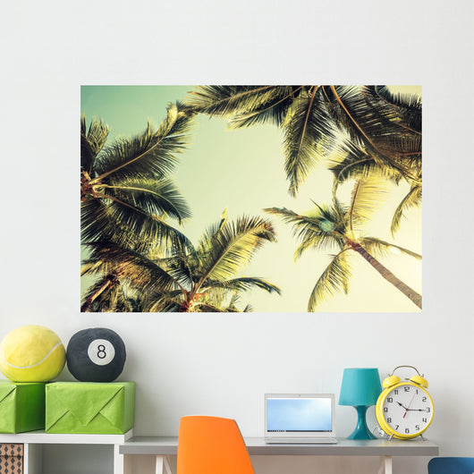 Coconut palm trees and shining sun over bright sky Wall Decal