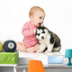 Little girl playing with a puppy husky, isolated on white Wall Decal