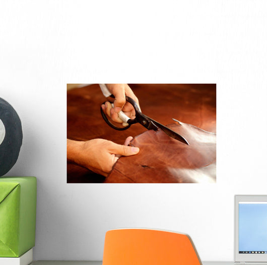 Tailor cutting animal skins at textile factory Wall Decal