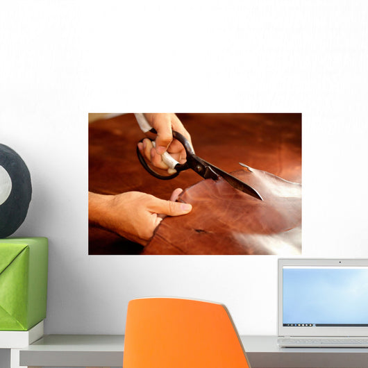 Tailor cutting animal skins at textile factory Wall Decal