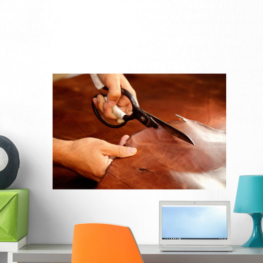 Tailor cutting animal skins at textile factory Wall Decal