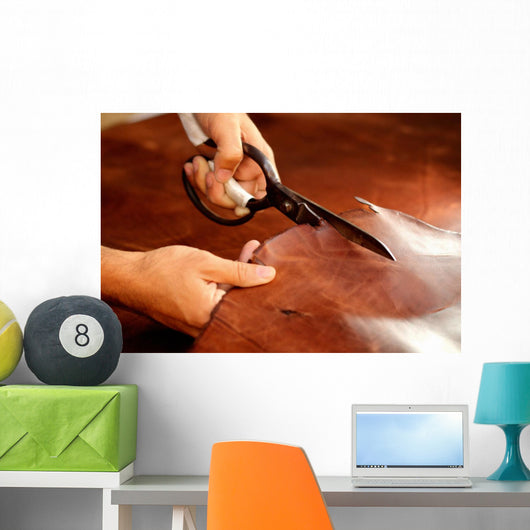 Tailor cutting animal skins at textile factory Wall Decal