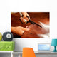Tailor cutting animal skins at textile factory Wall Decal