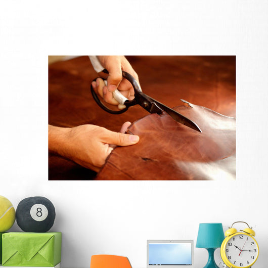 Tailor cutting animal skins at textile factory Wall Decal