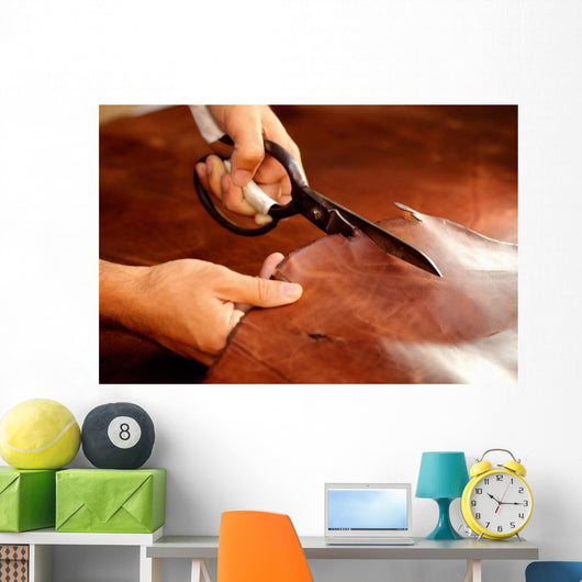 Tailor cutting animal skins at textile factory Wall Decal