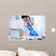Young woman doctor in white coat at computer using phone Wall Decal