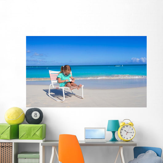 Little girl with laptop on beach during summer vacation Wall Decal