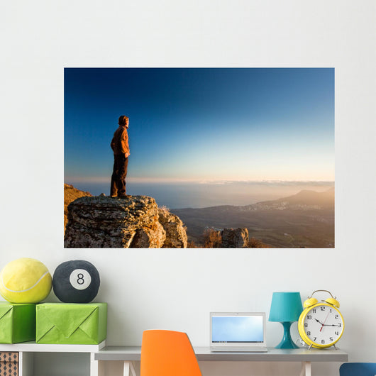 man on the cliff in mountains at sunset Wall Decal