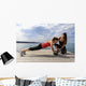 Young woman doing push-ups on a medicine ball with a coach Wall Decal
