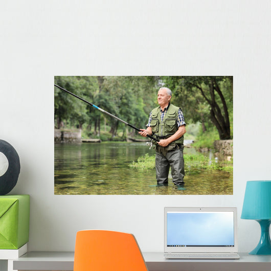 Cheerful mature fisherman fishing in a river Wall Decal