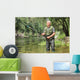 Cheerful mature fisherman fishing in a river Wall Decal