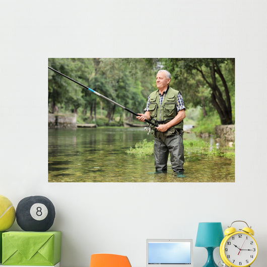 Cheerful mature fisherman fishing in a river Wall Decal