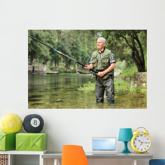 Cheerful mature fisherman fishing in a river Wall Decal