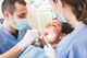 Dentist and Dental Assistant examining Patient teeth. Wall Decal