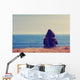 Girl sitting on a meadow with a beautiful sea/ocean view. Wall Decal