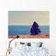 Girl sitting on a meadow with a beautiful sea/ocean view. Wall Decal