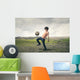 Boy playing football in the countryside Wall Decal