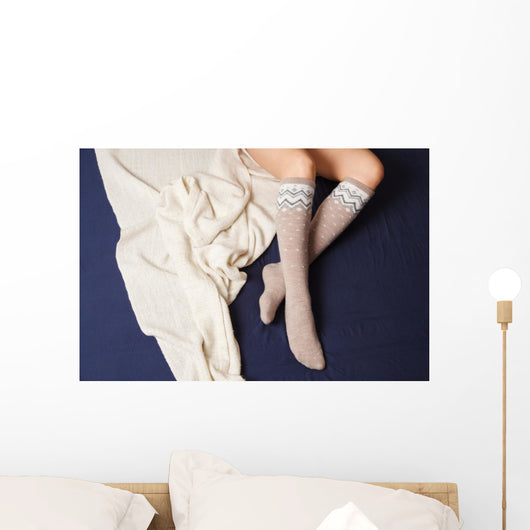 Female legs in warm woolen socks Wall Mural