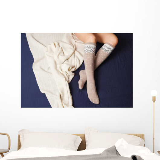 Female legs in warm woolen socks Wall Mural