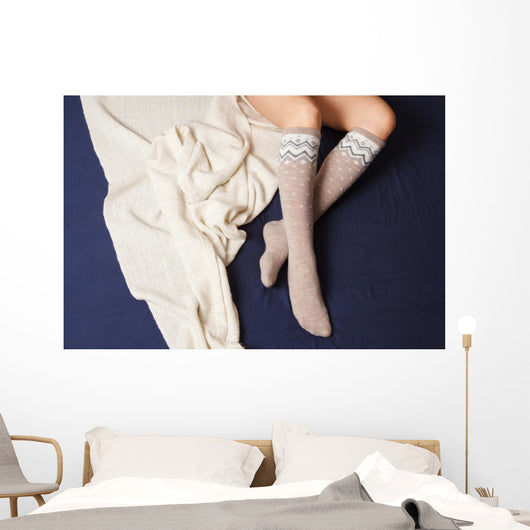 Female legs in warm woolen socks Wall Mural