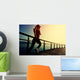 young fitness woman running on sunrise seaside boardwalk Wall Mural