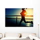 young fitness woman running on sunrise seaside boardwalk Wall Mural