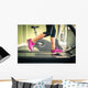 Fitness girl running on treadmill. With muscular legs in gym. Wall Mural