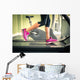 Fitness girl running on treadmill. With muscular legs in gym. Wall Mural