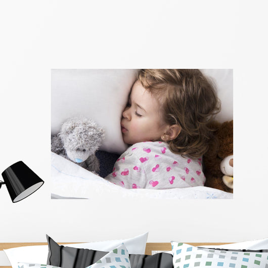 Sleeping child with toys Wall Mural