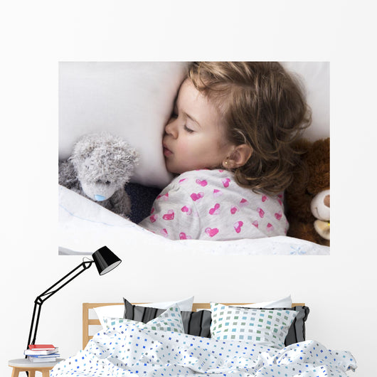 Sleeping child with toys Wall Mural