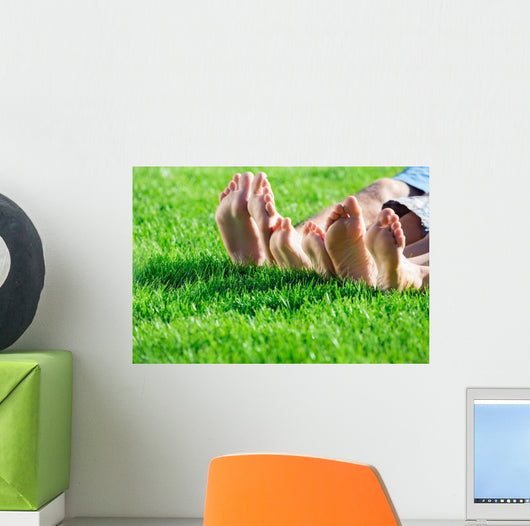 Family relaxing on the grass Wall Mural