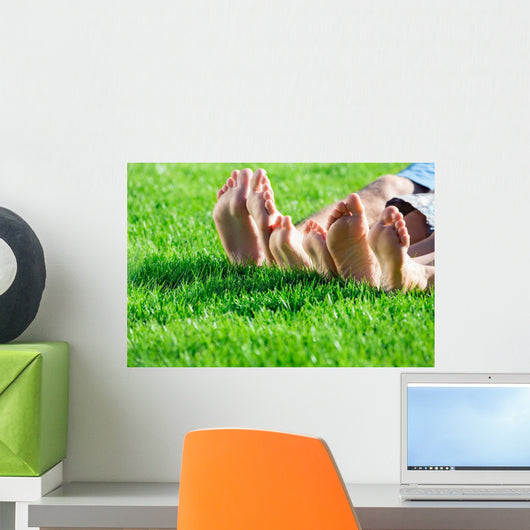 Family relaxing on the grass Wall Mural
