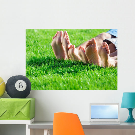 Family relaxing on the grass Wall Mural