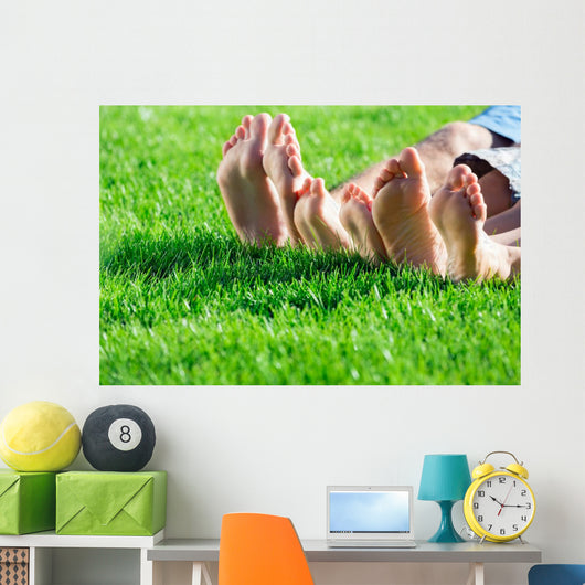 Family relaxing on the grass Wall Mural