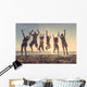 Multiracial group of people jumping at beach Wall Mural