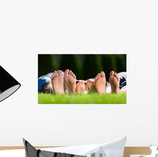 Family relaxing on the grass Wall Mural