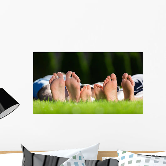 Family relaxing on the grass Wall Mural