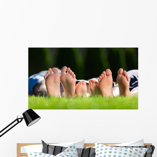 Family relaxing on the grass Wall Mural