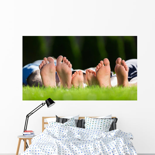Family relaxing on the grass Wall Mural