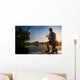 Young man fishing at misty sunrise Wall Mural