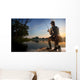 Young man fishing at misty sunrise Wall Mural